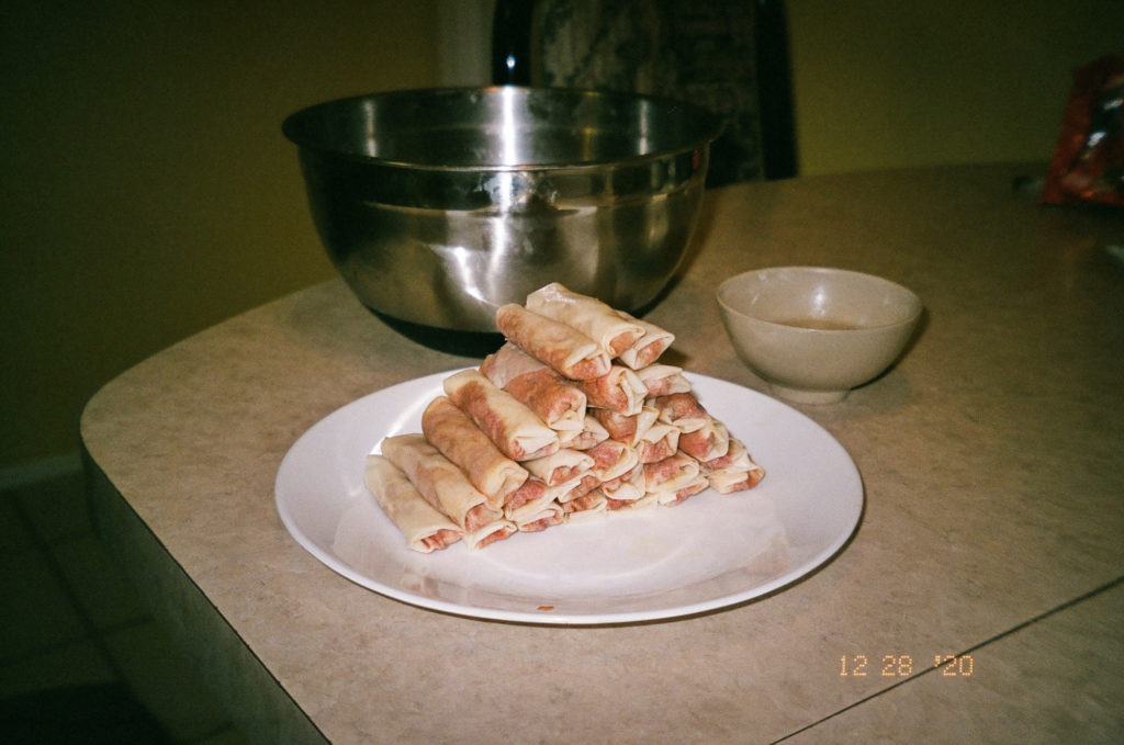 A white plate stacked high with lumpia.